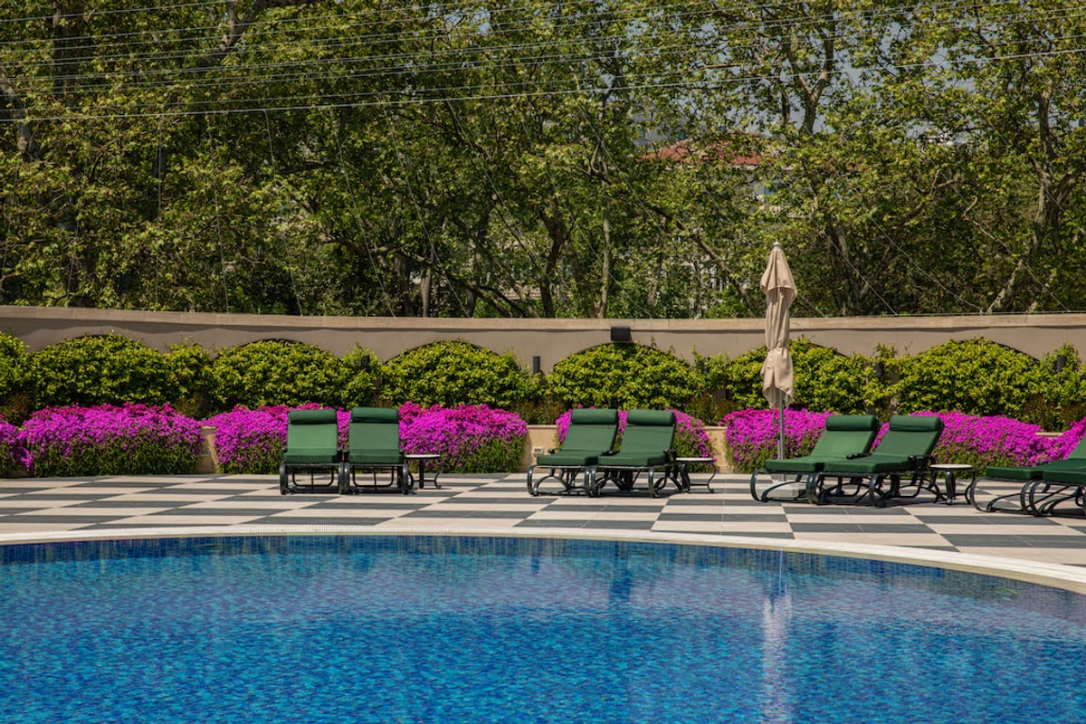 Pool deck loungers with the Bosphorus visible through the trees